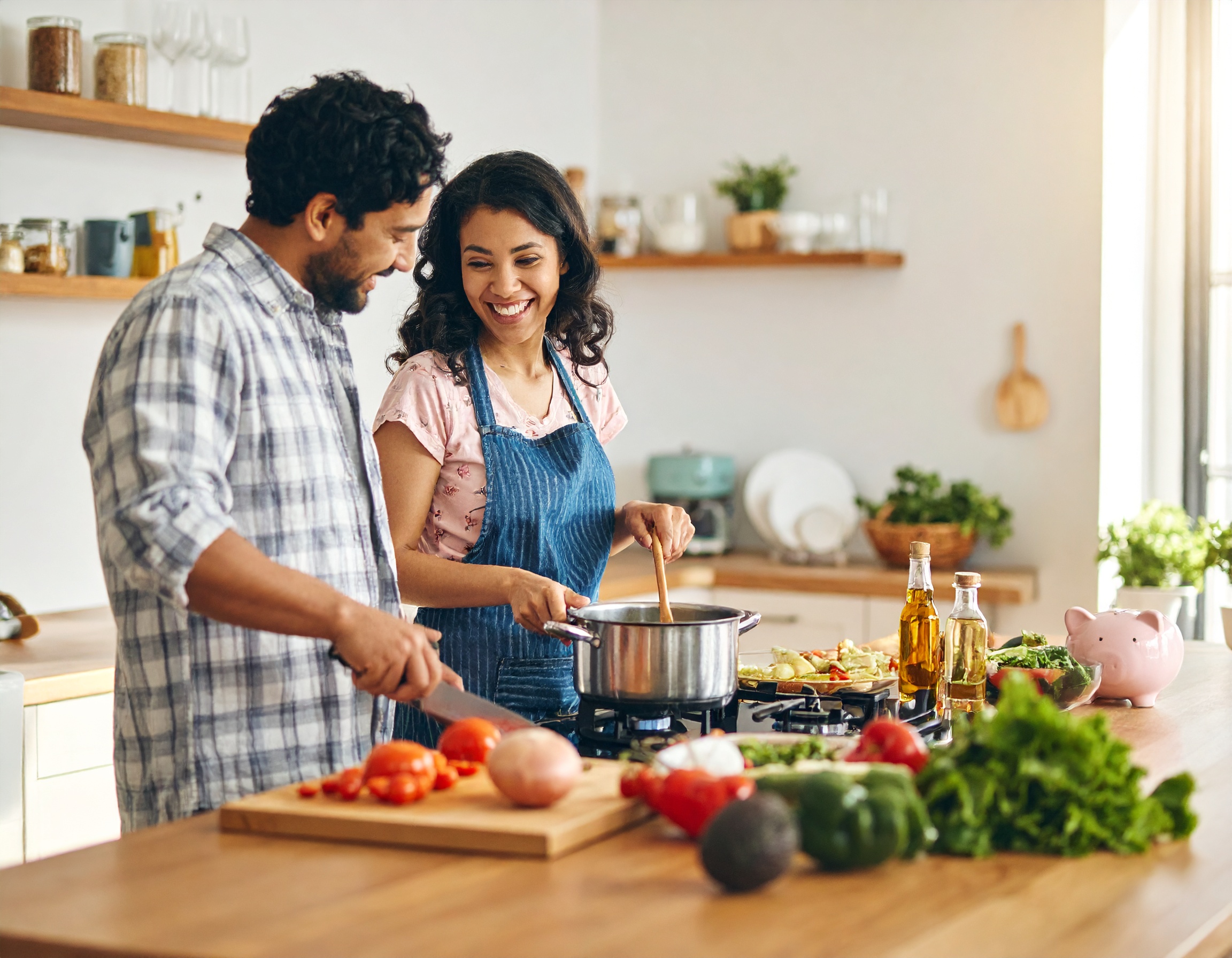 Couple cooking with piggy bank